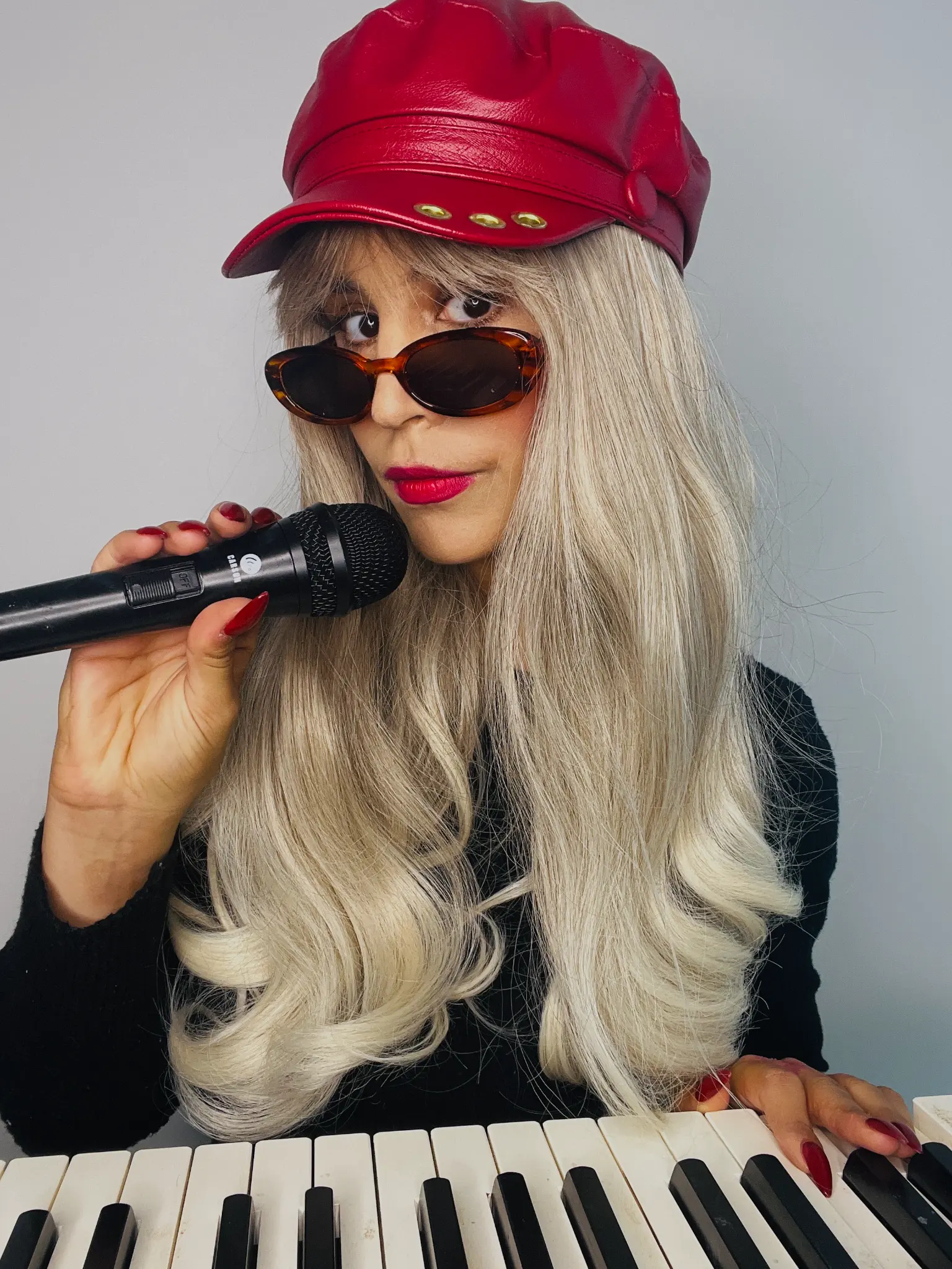 Portrait with a red cap, microphone and keyboard